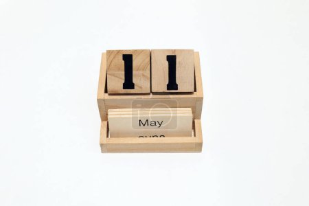 Close up of a wooden perpetual calendar showing the 11th of May. Shot close up isolated on a white background