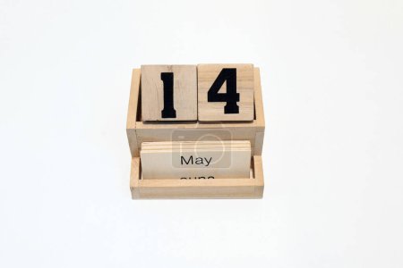 Close up of a wooden perpetual calendar showing the 14th of May. Shot close up isolated on a white background