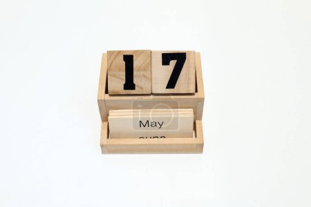 Close up of a wooden perpetual calendar showing the 17th of May. Shot close up isolated on a white background