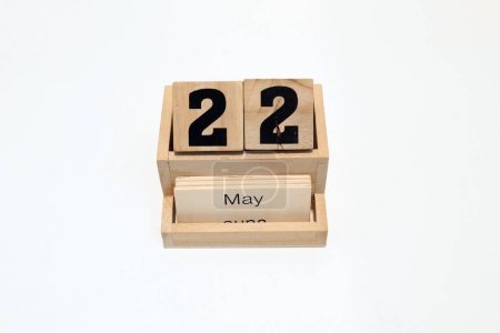 Close up of a wooden perpetual calendar showing the 22nd of May. Shot close up isolated on a white background