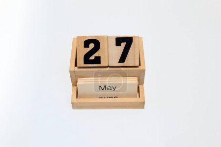 Close up of a wooden perpetual calendar showing the 27th of May. Shot close up isolated on a white background