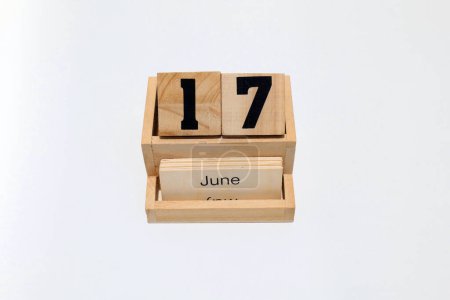 Close up of a wooden perpetual calendar showing the 17th of June. Shot close up isolated on a white background