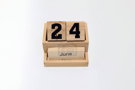 Nahaufnahme eines hölzernen ewigen Kalenders, der den 24. Juni zeigt. Nahaufnahme isoliert auf weißem Hintergrund