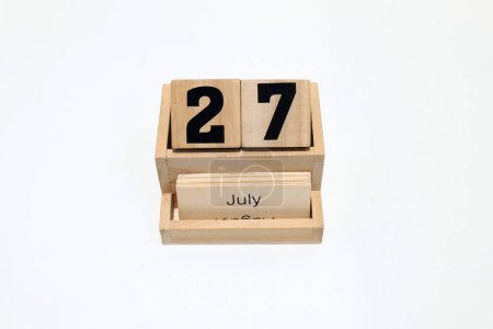 Close up of a wooden perpetual calendar showing the 27th of July. Shot close up isolated on a white background