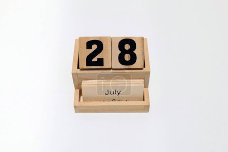 Nahaufnahme eines hölzernen ewigen Kalenders, der den 28. Juli zeigt. Nahaufnahme isoliert auf weißem Hintergrund