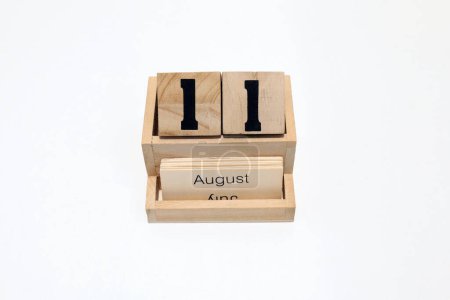 Close up of a wooden perpetual calendar showing the 11th of August. Shot close up isolated on a white background