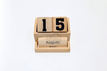 Close up of a wooden perpetual calendar showing the 15th of August. Shot close up isolated on a white background