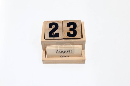 Close up of a wooden perpetual calendar showing the 23rd of August. Shot close up isolated on a white background