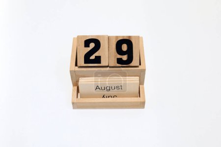 Close up of a wooden perpetual calendar showing the 29th of August. Shot close up isolated on a white background