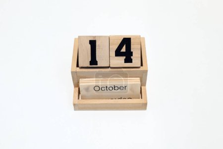 Close up of a wooden perpetual calendar showing the 14th of October. Shot close up isolated on a white background 
