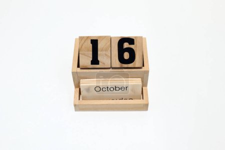 Close up of a wooden perpetual calendar showing the 16th of October. Shot close up isolated on a white background 