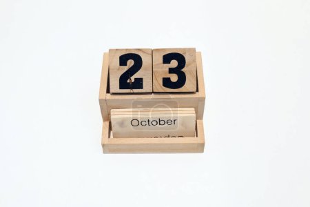 Close up of a wooden perpetual calendar showing the 23rd of October. Shot close up isolated on a white background 