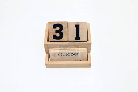Primer plano de un calendario perpetuo de madera que muestra el 31 de octubre. Disparo de cerca aislado sobre un fondo blanco 