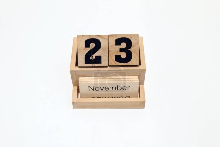 Close up of a wooden perpetual calendar showing the 23rd of November. Shot close up isolated on a white background 