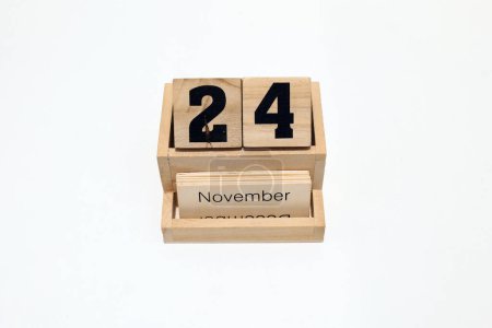 Close up of a wooden perpetual calendar showing the 24th of November. Shot close up isolated on a white background 