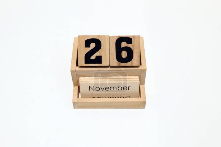 Close up of a wooden perpetual calendar showing the 26th of November. Shot close up isolated on a white background 