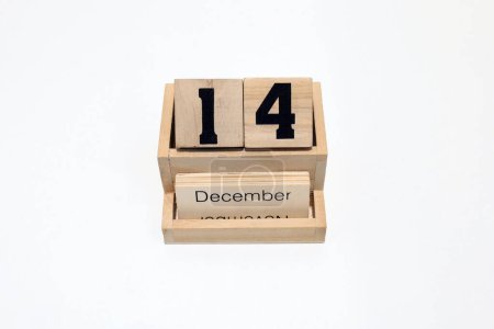 Gros plan d'un calendrier perpétuel en bois montrant le 14 décembre. Plan rapproché isolé sur fond blanc 