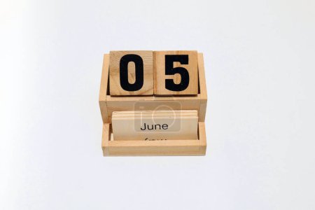 Nahaufnahme eines hölzernen ewigen Kalenders, der den 5. Juni zeigt. Nahaufnahme isoliert auf weißem Hintergrund
