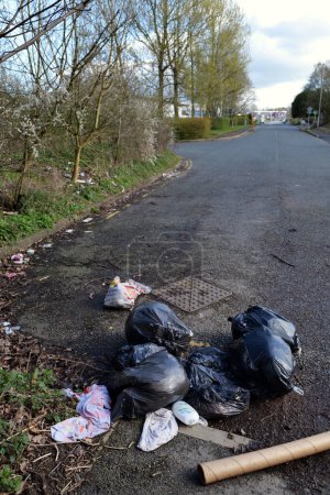 Photo for Carlisle, UK 03 29 2024 Black bin bags and waste fly tipped at end of empty lane. - Royalty Free Image