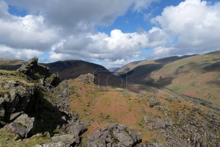 Rocky outcrop of the lion and lamb at the top of Helmcrag in the Lake District National Park. Cumbrian fells can be seen in the backdrop.