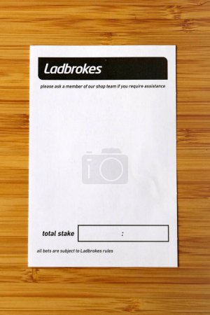 Foto de Bradford, Reino Unido 05 04 2024 Blank Labrokes apuesta deslizamiento disparo sobre un fondo de madera pálido - Imagen libre de derechos