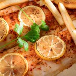 Flavorful Delight: Cajun Style Baked Fish Fillet with Fries and Lemon in Exquisite 4K Close-Up