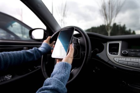 Foto de Conectado conmutar: Primer plano de conducción de coches hombre con Smartphone en 4K - Imagen libre de derechos