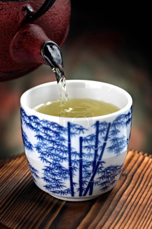  Gelassenheit in Bewegung: Nahaufnahme des Gießens von grünem Tee in eine Tasse, aufgenommen in exquisiter 4K-Auflösung