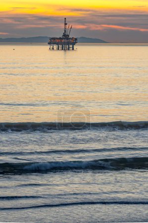 Téléchargez les photos : Convergence côtière : plate-forme pétrolière et surfeur à Huntington Beach, Californie, s'unissant harmonieusement sur film en résolution 4K - en image libre de droit