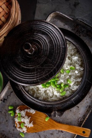 Téléchargez les photos : Fusion saine : Gros plan sur Edamame servi sur du riz blanc cuit à la vapeur dans un pot en fonte, capturé en résolution 4K - en image libre de droit