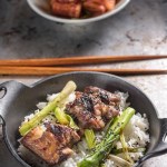 Mouthwatering Kalbi Delight: Top Close-Up of Delicious Grilled Kalbi on Steamed White Rice, Sizzling in a Cast Iron Pan, in 4K Resolution