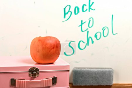 Téléchargez les photos : Retour à l'école Crunch : Gros plan d'une pomme sur une boîte à lunch, parfait pour visionner 4K - en image libre de droit