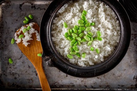 Téléchargez les photos : Fusion saine : Gros plan sur Edamame servi sur du riz blanc cuit à la vapeur dans un pot en fonte, capturé en résolution 4K - en image libre de droit
