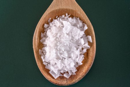 Natürliche Gewürze: 4K Ultra-HD-Bild von weißem Salz im Holzlöffel auf grünem Hintergrund