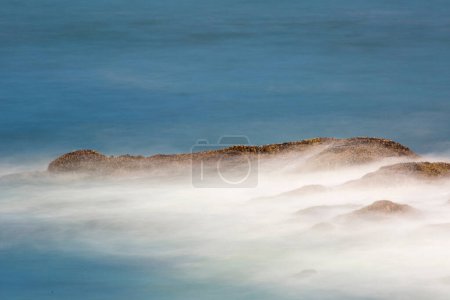 Dynamic Seascape: 4K-Ultra-HD-Bild von Ozeanwellen, die felsiges Ufer in Langzeitbelichtung zermalmen