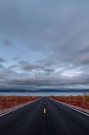 Desert Serenity: 4K Ultra HD Image of Desert Road Leading to Lakeshore with Clouds at Sunset