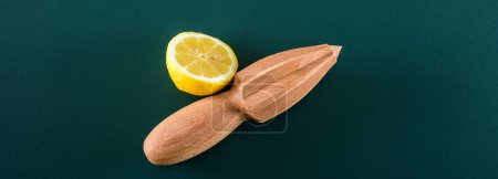 Photo for Fresh Citrus Display: 4K Ultra HD Image of Wooden Squeezer with Fresh Cut Lemon Slice on Green Background - Royalty Free Image