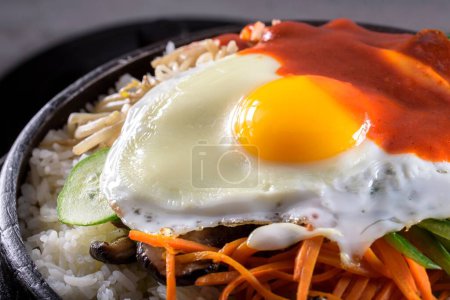 Sizzling Bi Bim Bap: 4K Ultra HD Draufsicht, gemischtes Gemüse, Reis und heiße Soße im Gusseisen-Topf