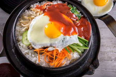 Sizzling Bi Bim Bap: 4K Ultra HD Top View, Verduras mixtas, arroz y salsa caliente en olla de hierro fundido