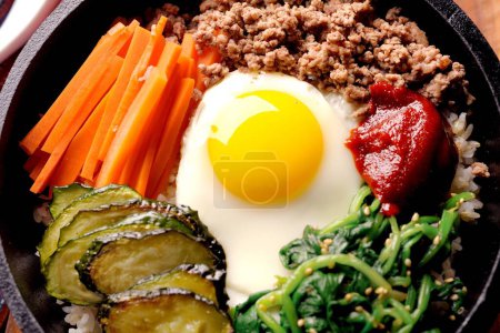 Sizzling Bi Bim Bap: 4K Ultra HD Top View, Mixed Vegetables, Rice, and Hot Sauce in Cast Iron Pot