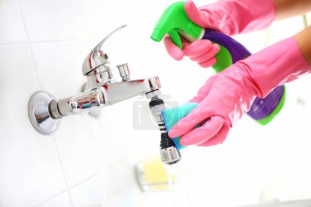 Everyday Cleaning Routine: Closeup of Unrecognizable Person's Hand in Pink Glove Cleaning Bathroom Faucet with Blue Cloth and Detergent from Plastic Bottle (4K Image)