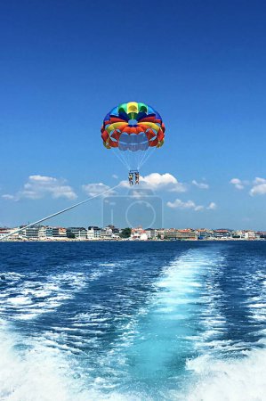 Photo for Thrilling Parasailing Adventure: Two People Soaring Over Sea on Summer Vacation Behind Speedboat (4K image) - Royalty Free Image