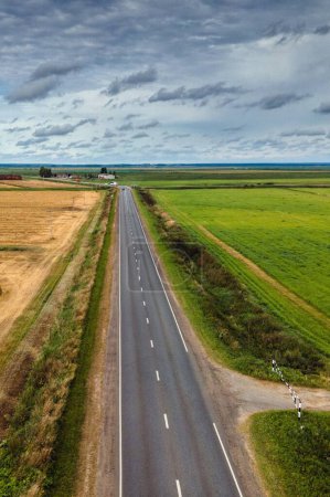 Carretera a través del corazón: 4K Ultra HD imagen de la vista aérea sobre la carretera de varios carriles en medio de campos agrícolas