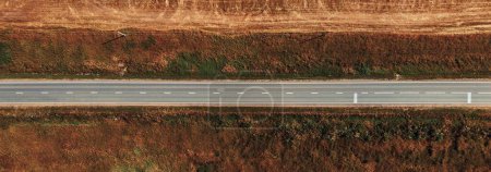 Autoroute à travers le Heartland : Image 4K Ultra HD De Vue Aérienne Sur La Route Multi-Voies Au Milieu Des Champs Agricoles