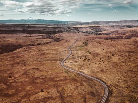  Grenzreise: Drohnenaufnahme eines Autos auf der Straße in Arid South Dakota, an der Grenze zu Wyoming, USA - 4K Ultra HD Foto
