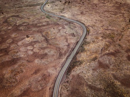  Grenzreise: Drohnenaufnahme eines Autos auf der Straße in Arid South Dakota, an der Grenze zu Wyoming, USA - 4K Ultra HD Foto