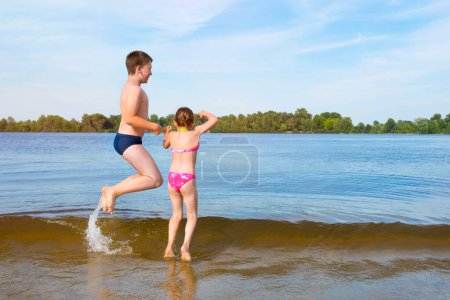 Photo for Happy children playing on the river on a sunny day. - Royalty Free Image