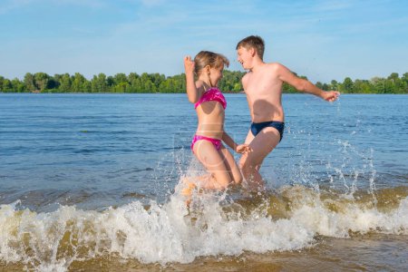 Foto de Los niños juegan en el río, saltan sobre las olas. Vacaciones para niños. - Imagen libre de derechos