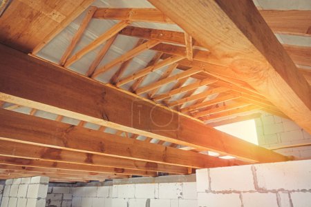 Photo for Construction of a wooden roof from beams and roofs. New home construction, interior view of the roof structure. - Royalty Free Image