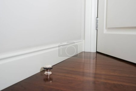 Téléchargez les photos : Moulure ornementale dans le coin d'une pièce blanche avec un concept intérieur en bois foncé. Belle vue intérieure - en image libre de droit